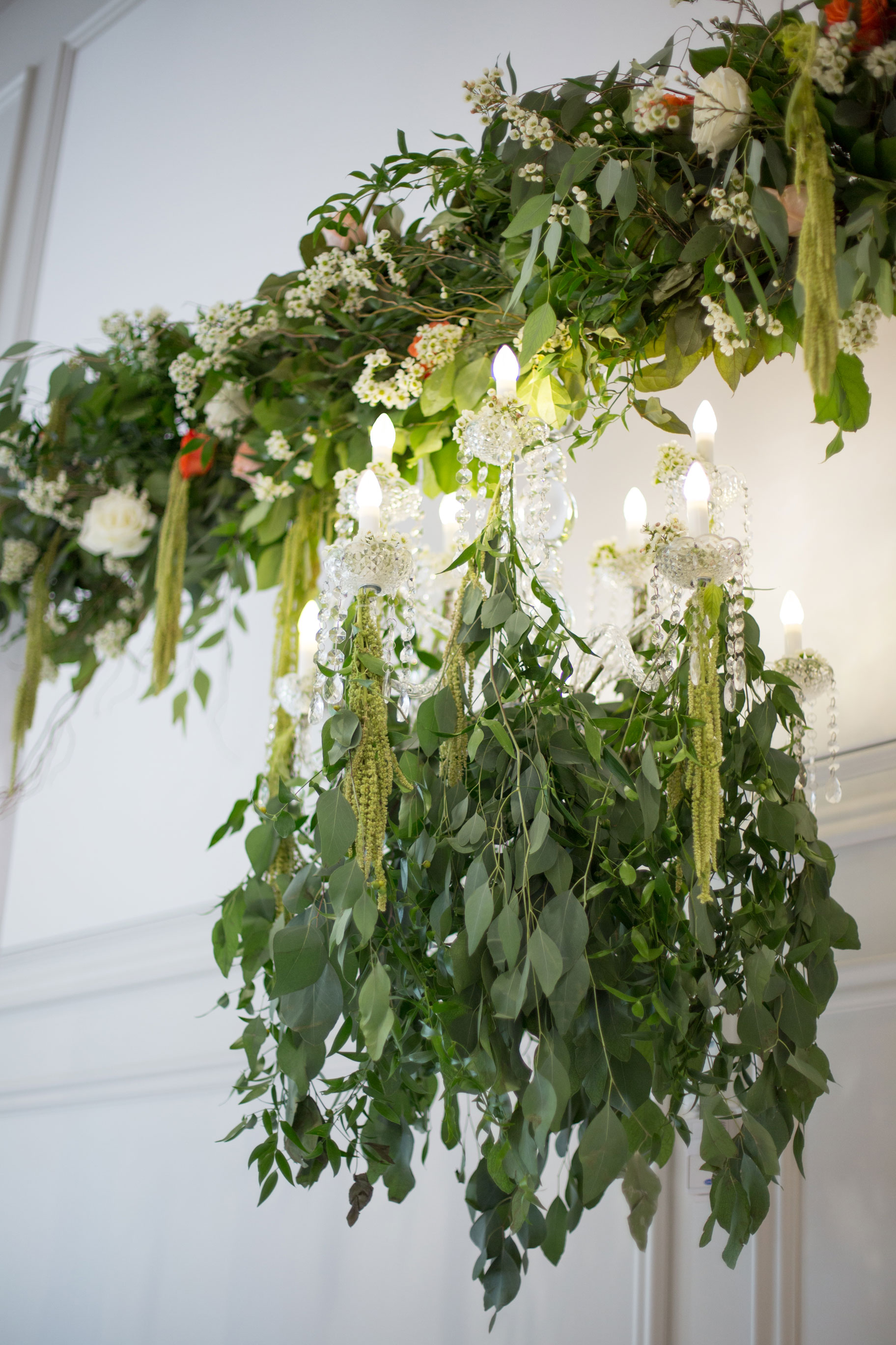 Garden style event with an abundance of greenery and beautiful shades of orange. Mix of long harvest tables and round tables with lots of candles.