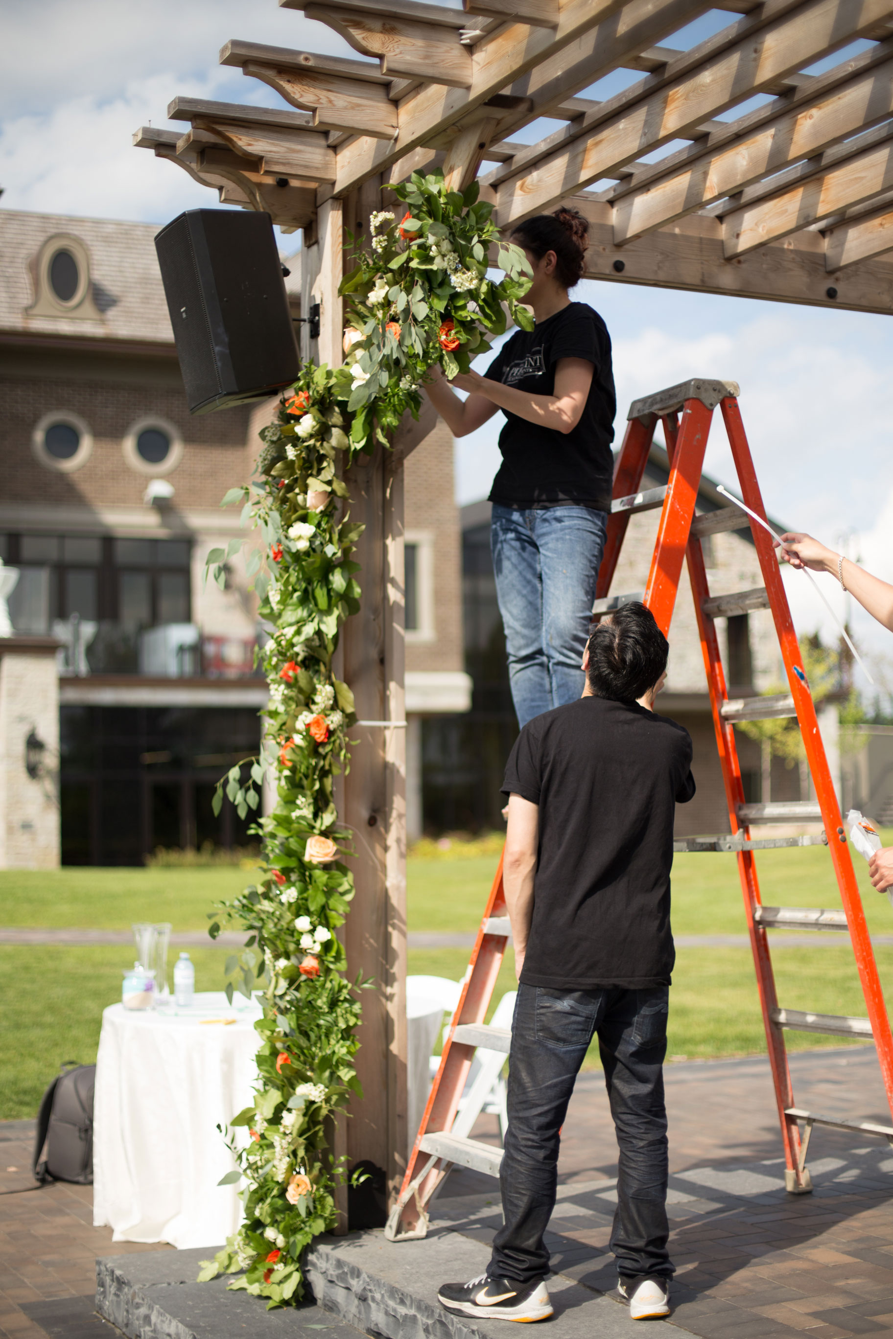 Garden style event with an abundance of greenery and beautiful shades of orange. Mix of long harvest tables and round tables with lots of candles.